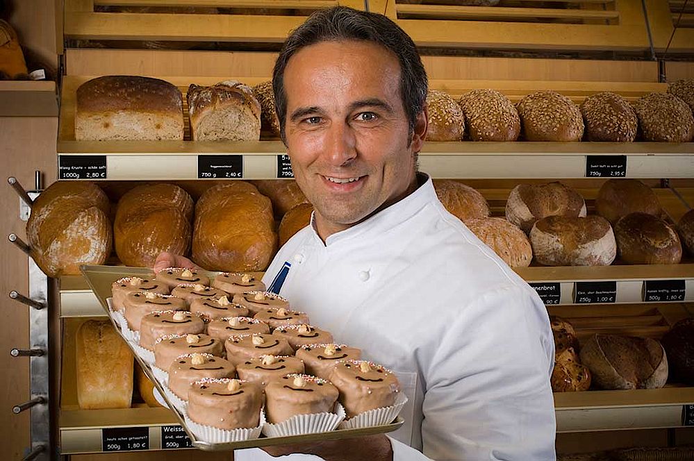 Bäckereimeister präsentiert Backwaren, hergestellt unter hohem Energieverbrauch