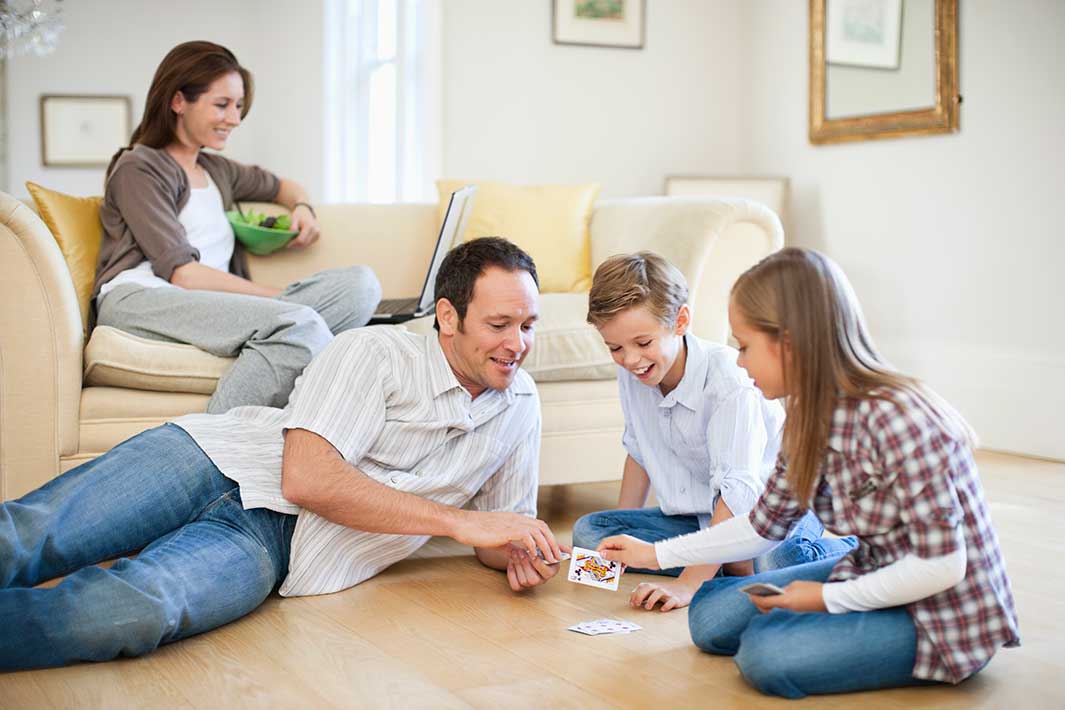 Familie beim Kartenspiel in beheizter Wohnung