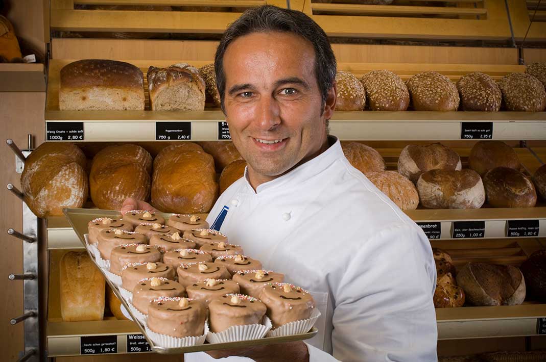 Bäckereimeister präsentiert Backwaren, hergestellt unter hohem Energieverbrauch